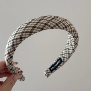 Detail of brown and white plaid fabric headband with a high-quality handmade label inside