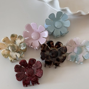 Vue détaillée de six pinces à cheveux en acétate fleuri aux couleurs et motifs marbrés