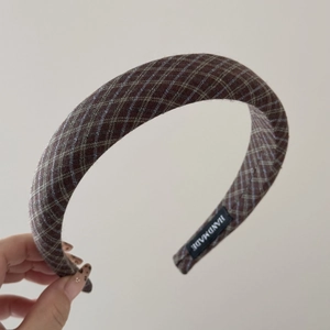 Detail of handmade padded plaid headband showing high-quality fabric and woven label