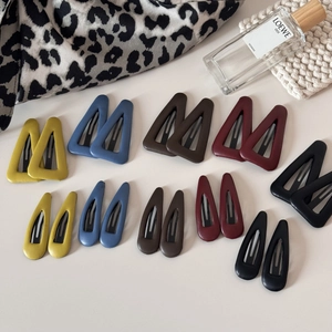 Détails d'un lot de barrettes à cheveux en cuir coloré de formes triangle et goutte