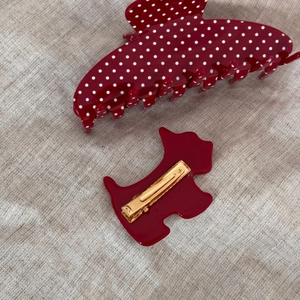 Close-up of red polka dot fan-shaped claw clip and puppy hairpin with metal grip
