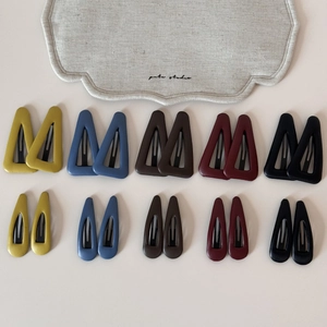 Gros plan d'un lot de barrettes en cuir mat de formes triangulaires et de gouttes colorées