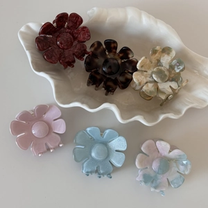 Détail des pinces à cheveux fleur en acétate 3D en six couleurs sur plateau blanc