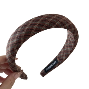 Vintage checkered plaid headband in woven fabric with handmade label on white background