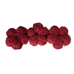 Handmade red crochet floral hair clip with three knit flowers on a white background