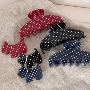 Detailed view of polka dot acetate hair claws with sparkling rhinestone puppy details