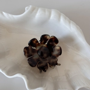 Détail de la pince à cheveux fleur avec texture écaille de tortue et ressort métallique