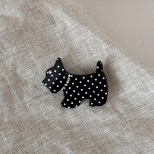 Detailed close-up of a black polka dot Scottie dog hair clip with sparkling rhinestones