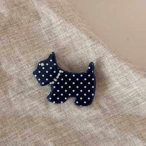 Detailed view of a Scottish Terrier dog brooch with blue and white polka dot acetate finish