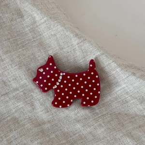 Red acetate dog hair claw with white polka dots and sparkling rhinestone collar detail