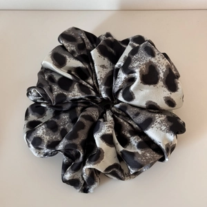 Detail view of large leopard print scrunchie in silver satin with soft textures