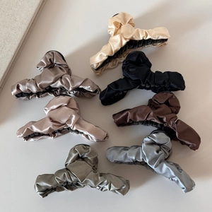 Detail von sieben eleganten plissierten Satin-Haarklammern in verschiedenen Farben