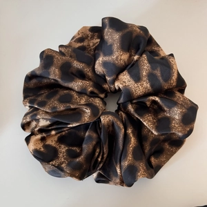 Detailed view of the smooth leopard print satin texture and silk-like fabric folds