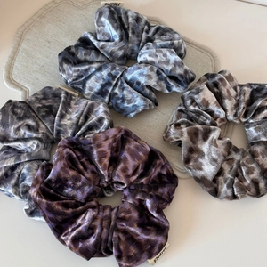 Lot de quatre chouchous en velours imprimé léopard en tons gris, brun et violet