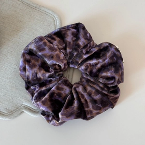 Vue détaillée du chouchou en velours à motif léopard avec une texture plissée