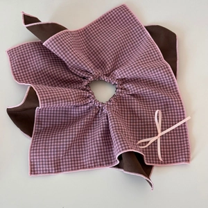 Detail view of pink and brown plaid bow hair tie with high-quality fabric texture