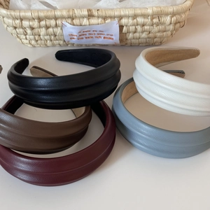 Macro shot of stylish thick PU leather headbands in black, white, brown and burgundy colors