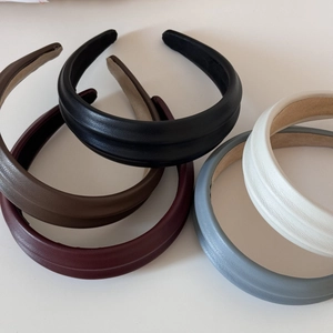 Flat lay of five faux leather padded headbands in various vintage matte colors