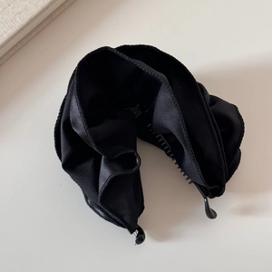 Makroansicht der schwarzen Satin-Bananenspange mit plissiertem Stoff und inneren Zähnen