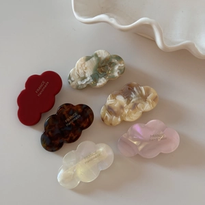 Detail of cloud-shaped acetate mini hair clips in six vibrant colors and marble patterns