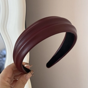 Close-up of wine red faux leather padded headband showing textured surface and lining