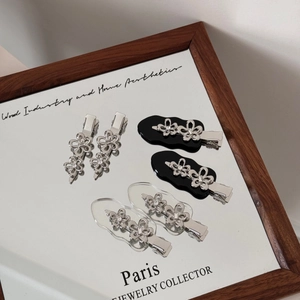 Detailaufnahme silberner Blumen-Haarspangen aus Metall mit funkelnden Strasssteinen