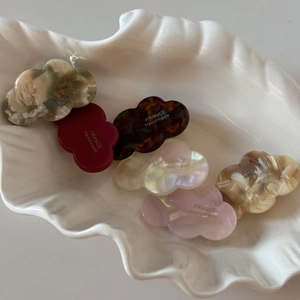 Detailed shot of mini acetate cloud hair clips in colorful finishes on a shell plate