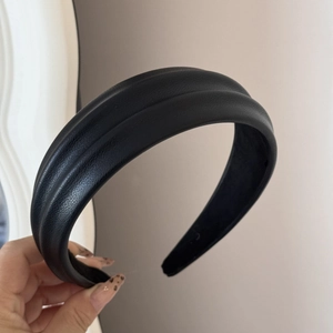 Detail of black faux leather headband showing textured double-ribbed design and non-slip lining