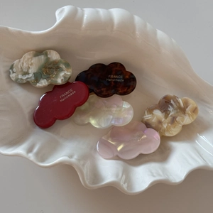 Close-up of 6 mini cloud-shaped acetate hair clips with France Handmade gold engraving