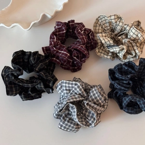 Flache Ansicht von fünf karierten Haargummis mit Handmade-Label in bunten Farben