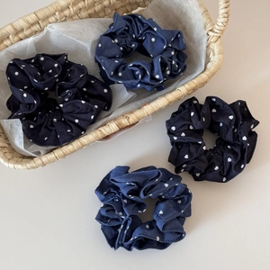 Close-up detail of retro denim hair scrunchies with white heart and polka dot patterns