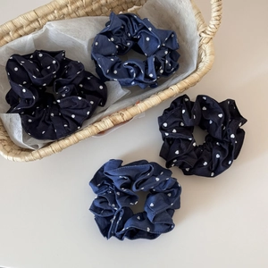 Detail of four navy and black denim heart polka dot fabric scrunchies in a woven basket