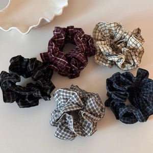 Set aus 5 Stoff-Haargummis mit Karomuster und Handmade-Etikett auf weißem Hintergrund