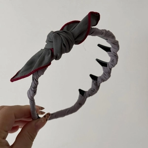 Détail du serre-tête en tissu gris foncé avec bordure rouge et dents antidérapantes