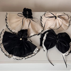Elegant beige and black bow hair ties with lace trim and gold charm detail