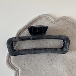 Macro shot of large gray marble ink pattern hair claw clip with geometric resin frame