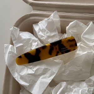 Detail of tortoise shell acetate hair clip with gold lettering in a premium gift box