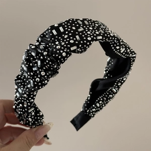 Detail view of black velvet headband with sparkling rhinestones and silver studs texture