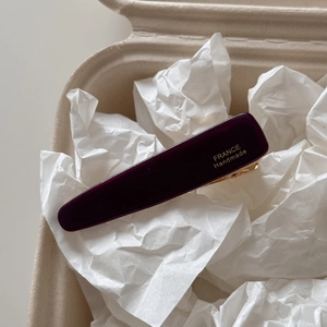 Detail of elegant dark purple acetate hair clip with golden France Handmade lettering