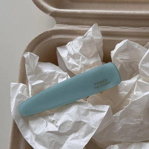 Detail view of light blue acetate hair clip with France Handmade gold engraving