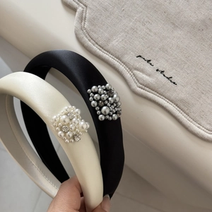 Close-up of black and cream satin headbands with pearl and rhinestone square details
