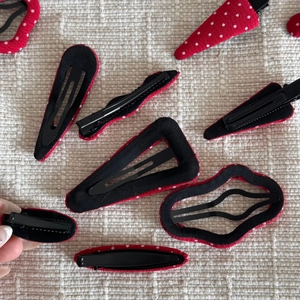 Détail des barrettes à pois rouges et blancs avec clips métalliques noirs solides