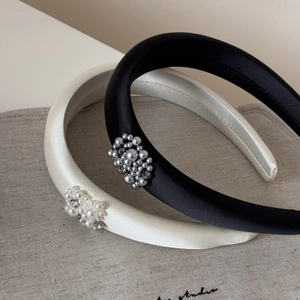 Detailed view of padded satin headbands with sparkling rhinestones and cluster pearls
