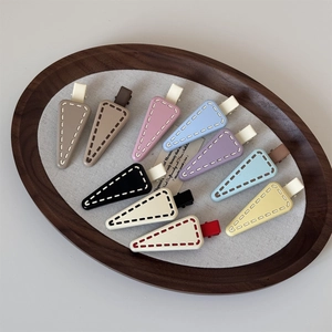 Set of 10 matte triangle hair clips in Morandi colors with stitching pattern on a tray