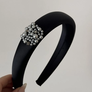 Detailed shot of black satin headband featuring grey pearls and sparkling rhinestones