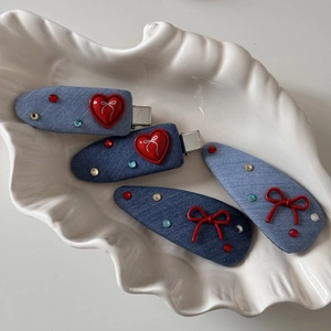 Denim blue hair clips set with red heart and bow accents and colorful rhinestones