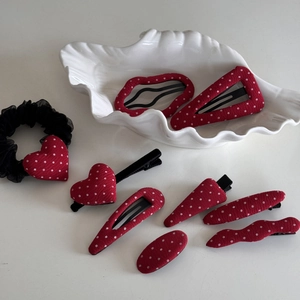 Détail de l'ensemble de barrettes à pois rouges et blancs et chouchou sur plateau blanc