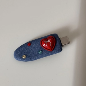 Detail of blue denim hair clip featuring a red heart and colorful rhinestones