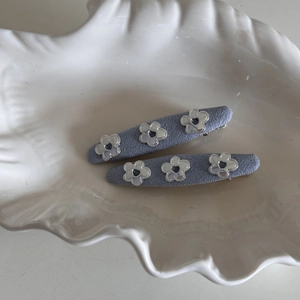 Detailed view of blue fabric denim hair clips with silver flower and heart-shaped cutouts