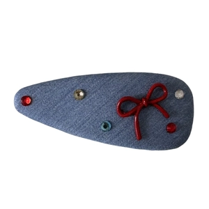 Blue denim snap clip featuring a red bow and multi-colored sparkling rhinestones
